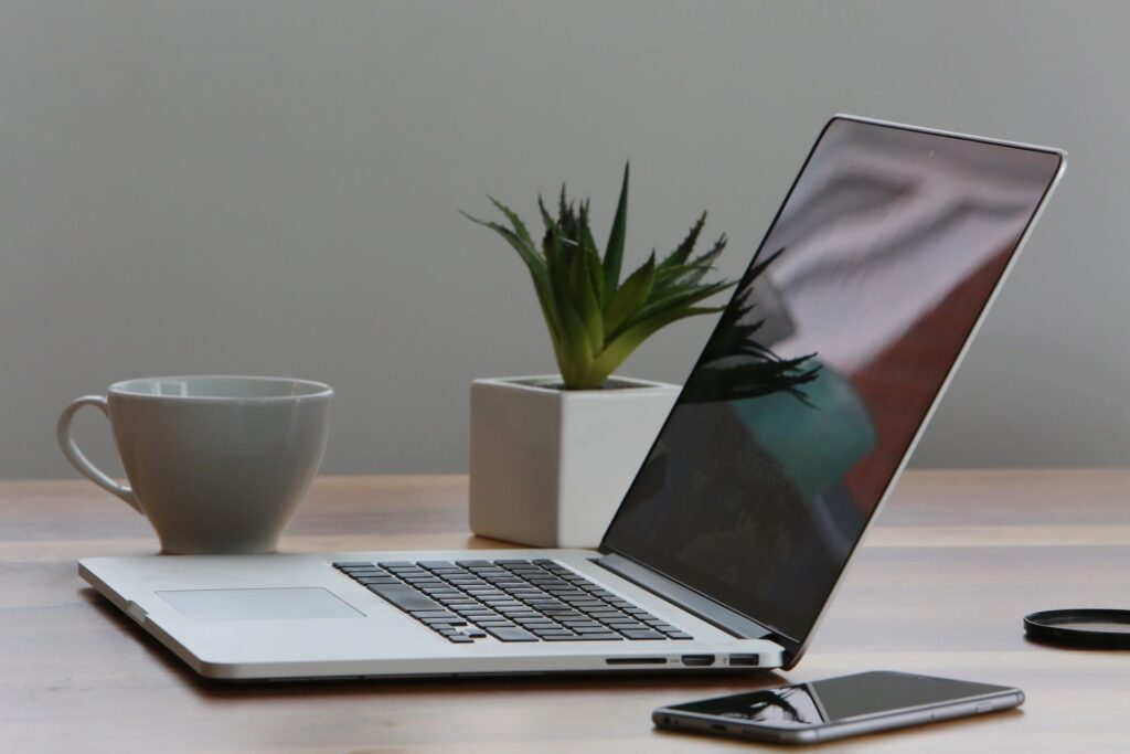 Compute, cup of coffee, and a phone on top of a table for work